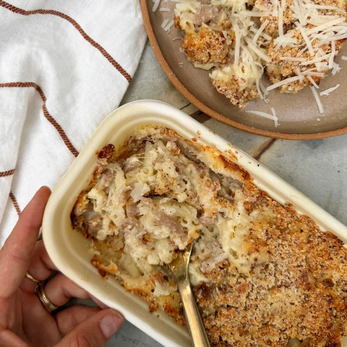 Creamy mac and cheese with crispy breadcrumb topping, ready to serve from a takeout container