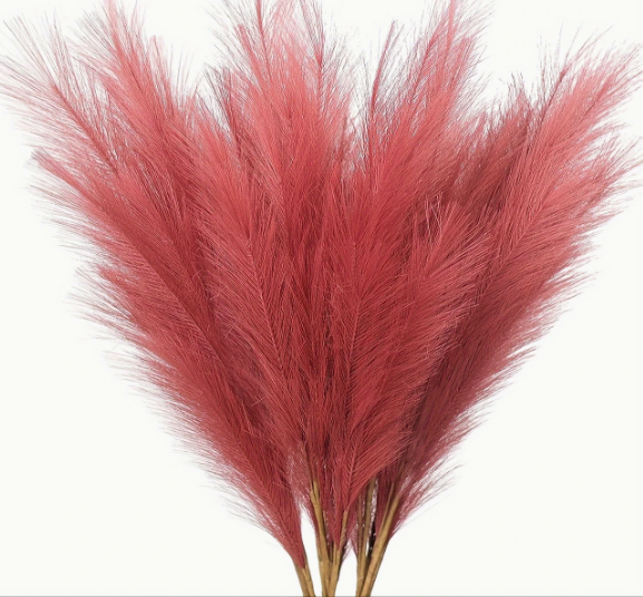 A bunch of artificial pampas grass with red plumes.