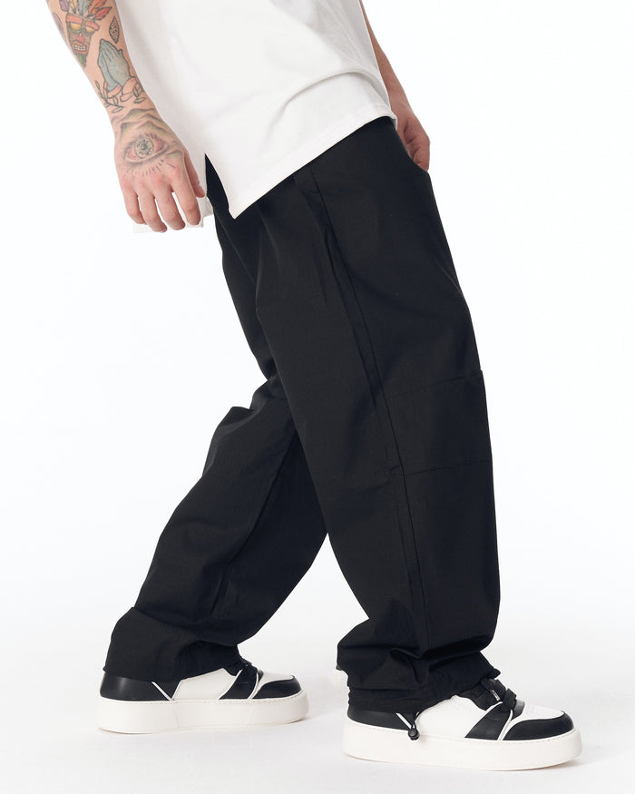 Martin Valen black wide-leg trousers with adjustable cuff, side view showing ankle drawcord