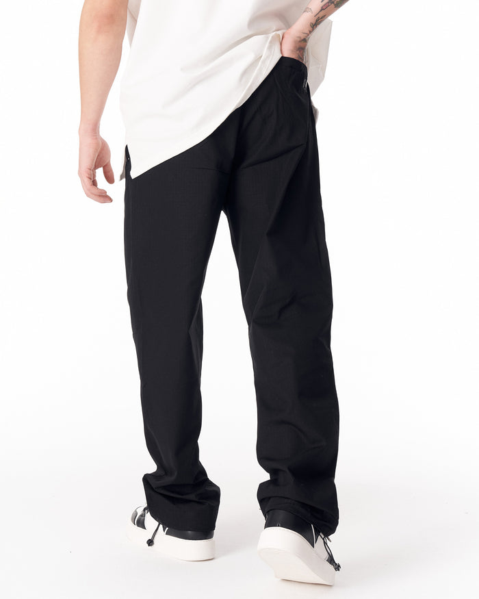 Martin Valen black wide-leg trousers, three-quarter view showing back pocket and white tee