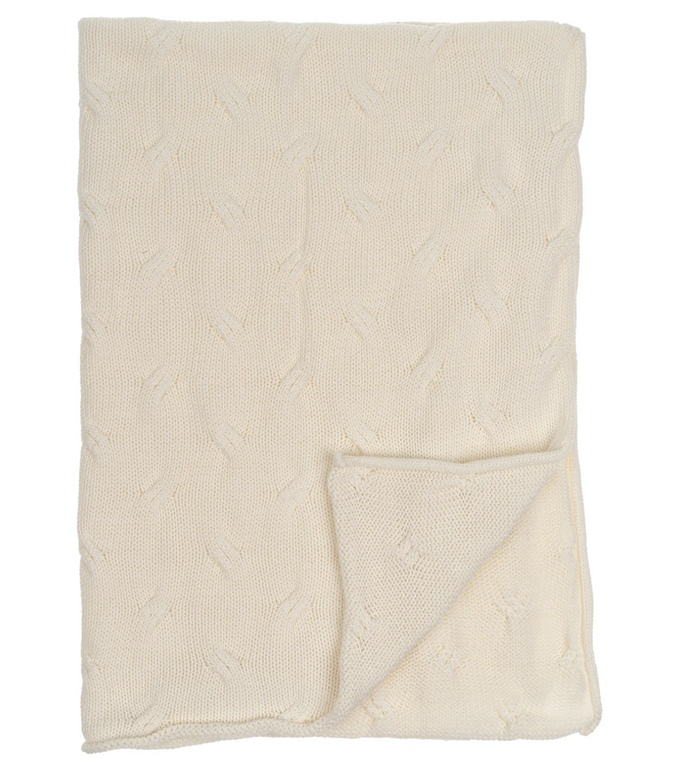 A beige knit baby blanket with wave-like detailing, folded and displayed on a flat surface.