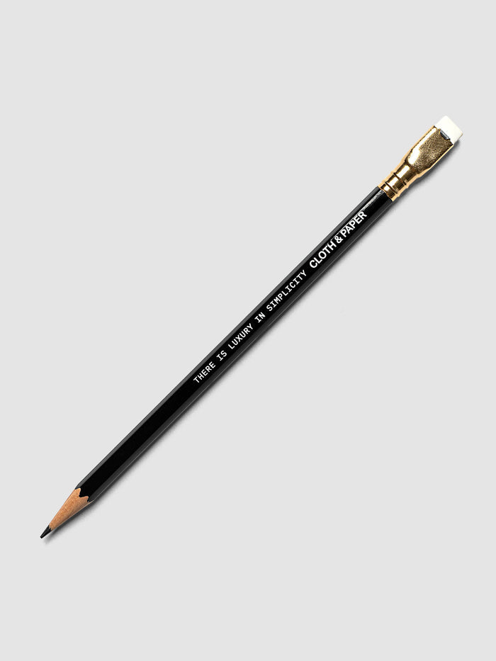 A single black Backwing pencil with a gold ferrule and white eraser, shown diagonally on a light gray background. The pencil reads 'THERE IS LUXURY IN SIMPLICITY' and the Cloth & Paper logo.