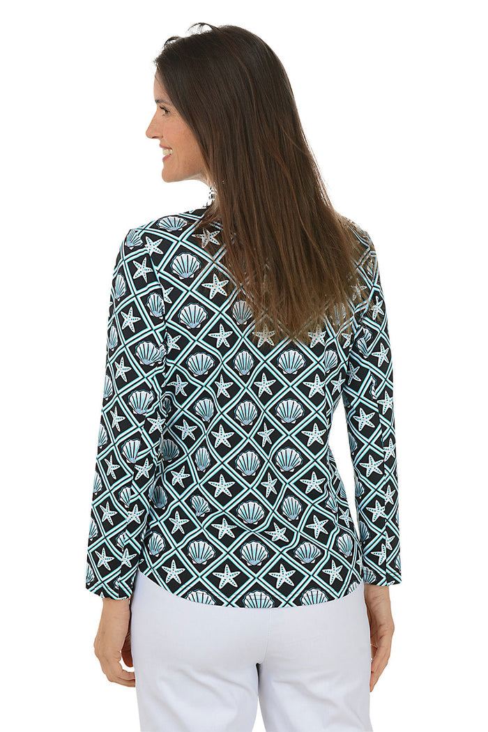 Woman wearing a patterned long-sleeve shirt with a white background. Back shot.
