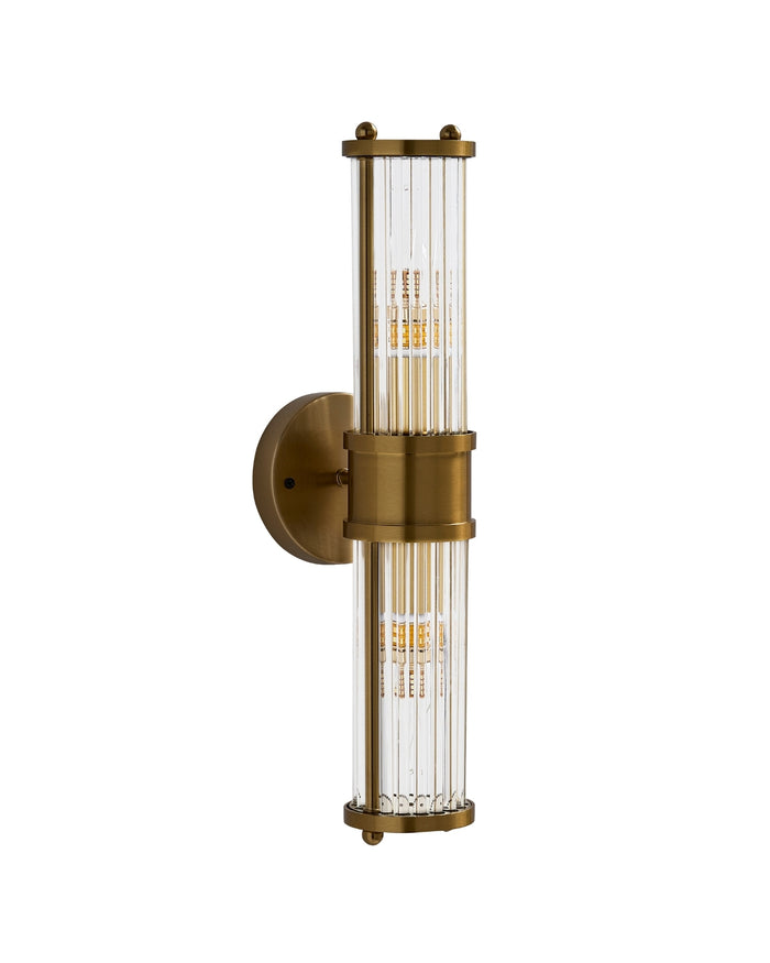 Brimsley II Wall Sconce with a vertical brass frame and ripple-textured clear glass, shown unlit on a white background, highlighting its sleek, elongated silhouette and refined detailing.