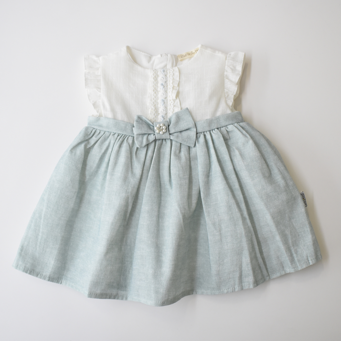 Baby girl dress with white ruffle-sleeve bodice, lace front detail, and light blue skirt accented by a bow with pearl embellishment at the waist.