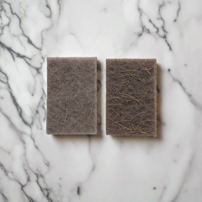 Natural fibre scouring pads on white marble kitchen counter – compostable cleaning pads in Calgary from Cuprea