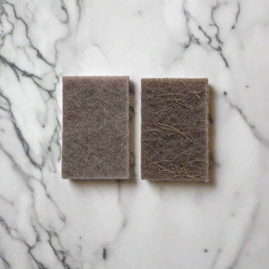Natural fibre scouring pads on white marble kitchen counter – compostable cleaning pads in Calgary from Cuprea
