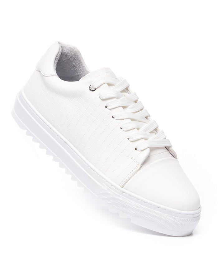 Martin Valen Dino low-top white sneaker close-up, diagonal view showing laces, textured croc upper and thick ridged sole