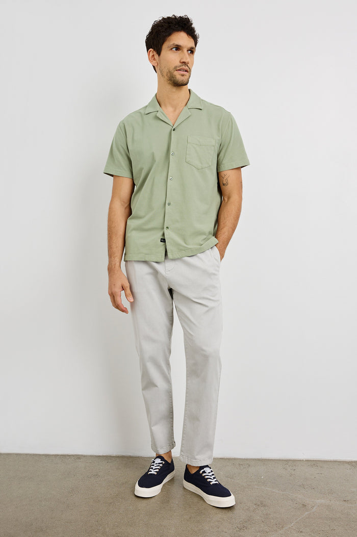 Flint Collared Button Shirt with Short Sleeves and a Chest Pocket in Sage Colorway. Front View Shown on Model.