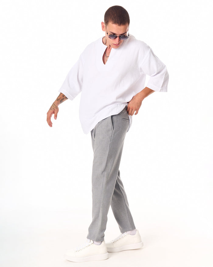 Martin Valen gray casual slim-fit trousers, three-quarter side view with hand in pocket and tapered ankle
