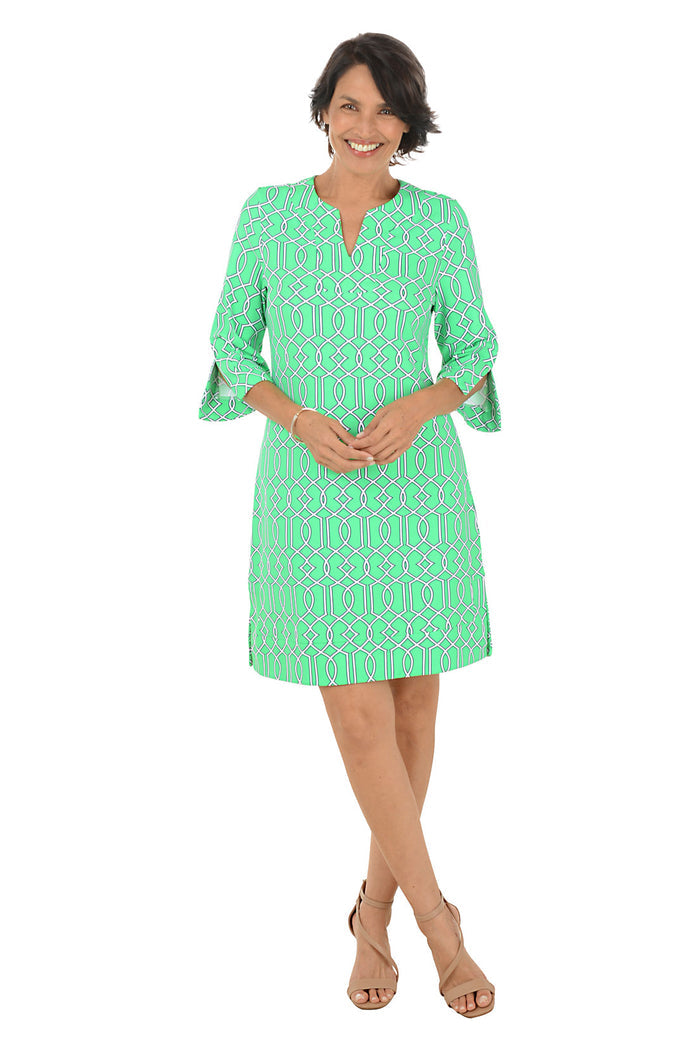 Woman wearing a green patterned dress on a white background.