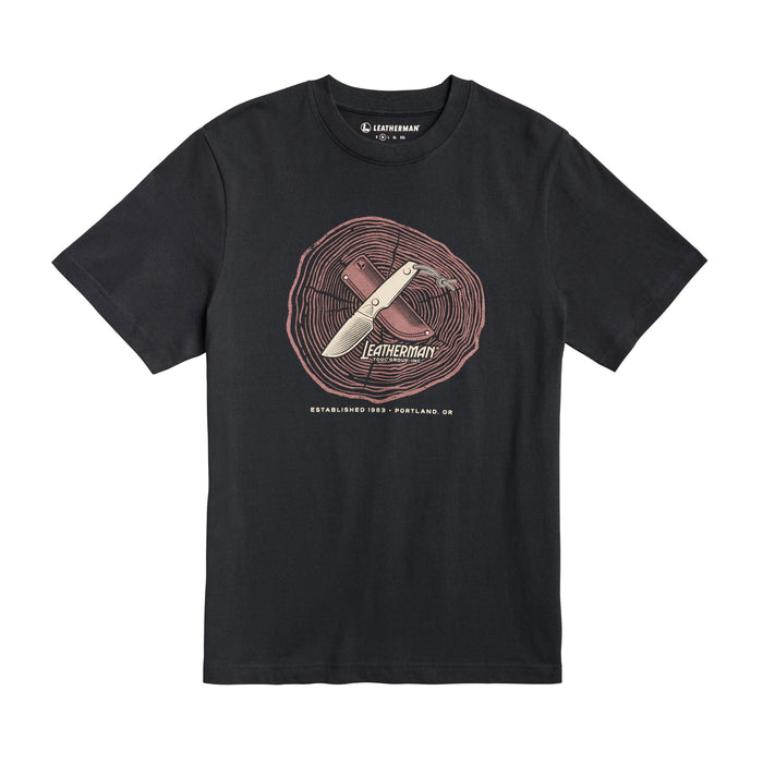 Front of the black Leatherman Blade & Grain tee  showcasing a fix blade knife and leather sheath on a stump