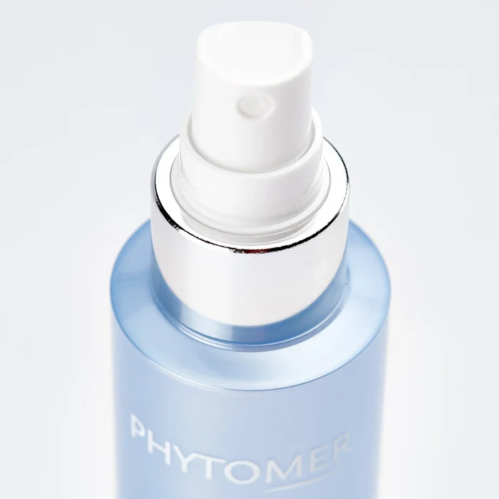 Close-up of a spray bottle featuring the skincare product Marine Mist | Phytomer with a white nozzle and light blue container, perfect for refreshing skincare routines.