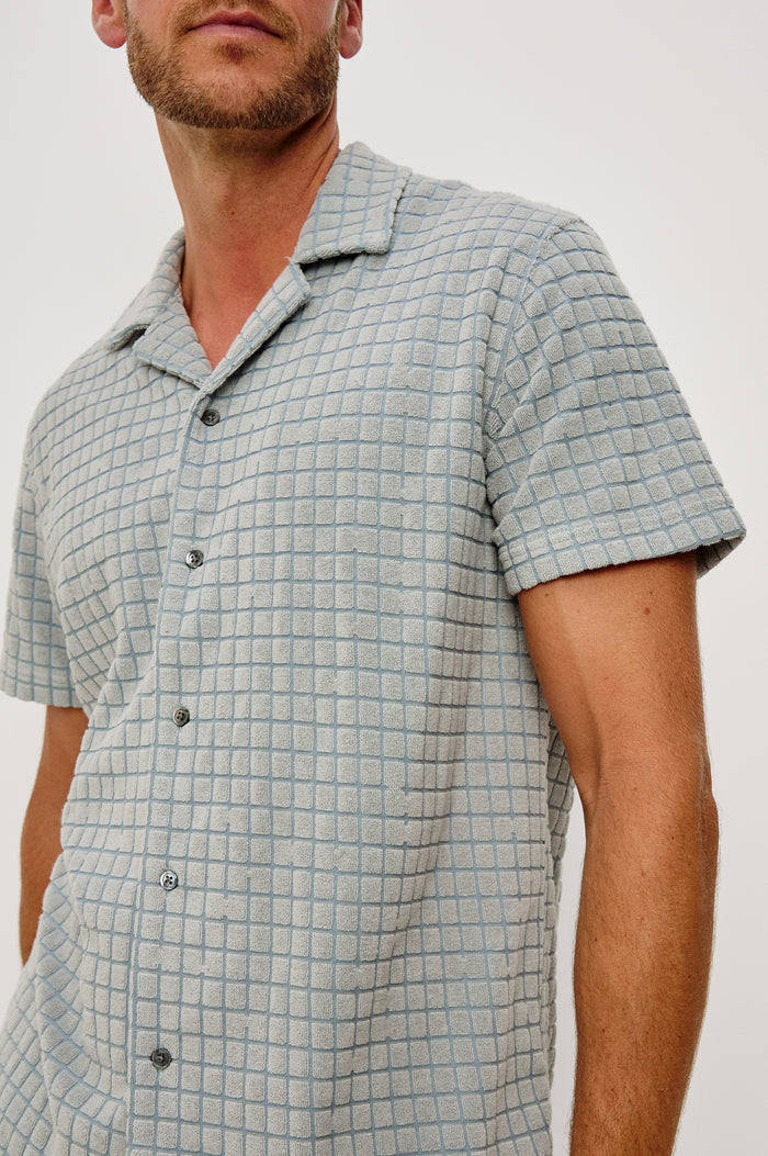 Maverick Short Sleeve Shirt in French Terry With Jacquard Pattern, Notched Collar, Front Buttons, and Classic Fit in Silver Line Blue Grid Colorway - Upper Body Close Up Front View Featured on Model