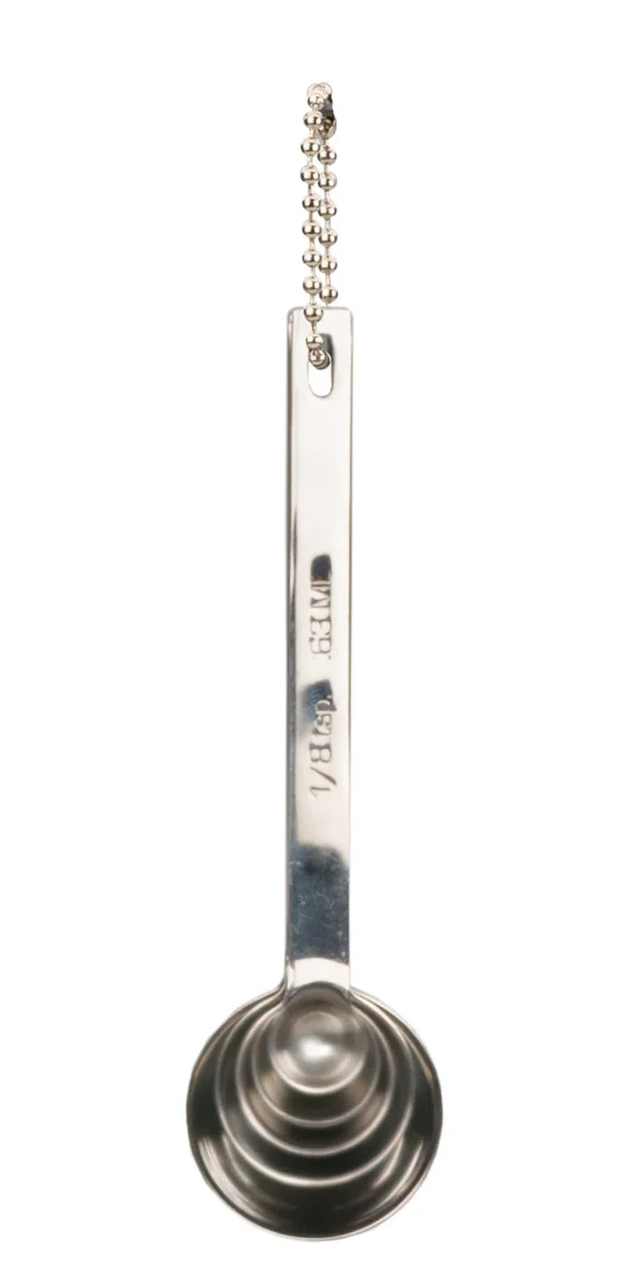 Metal measuring spoon with chain on a white background