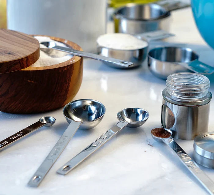 Set of measuring spoons and containers on a kitchen counter