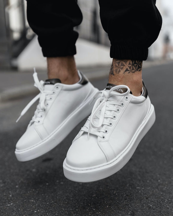 Martin Valen Iconic men's casual sneakers in white with black heel tab, front three-quarter view showing ankle tattoo