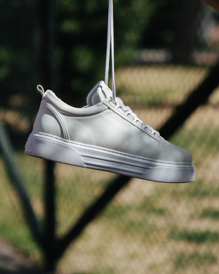 Martin Valen Trine men's white casual sneaker side view, hanging by laces with platform sole visible