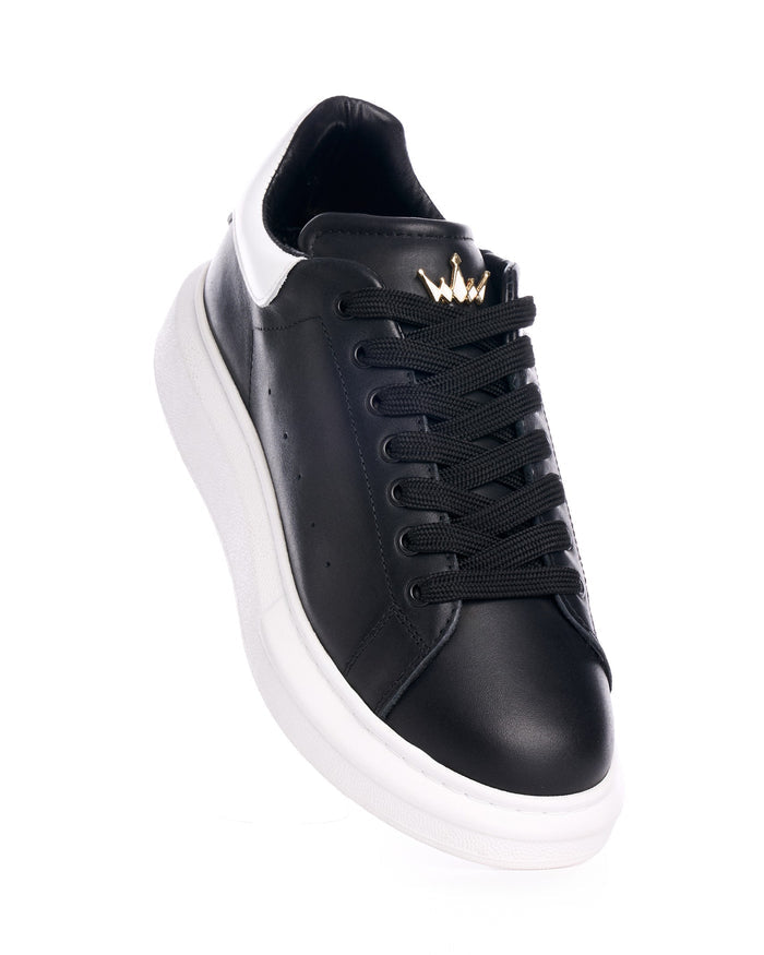 Martin Valen men's black and white leather sneakers, front-top angle close-up showing gold crown detail on the tongue