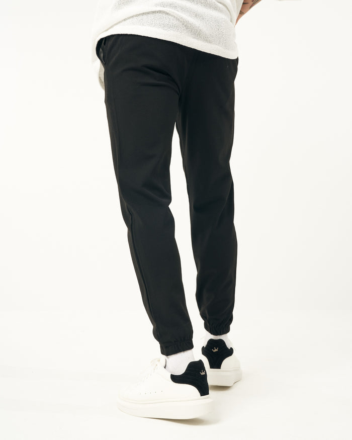 Martin Valen men's black jogger, three-quarter front view highlighting loose fit and elastic cuffs