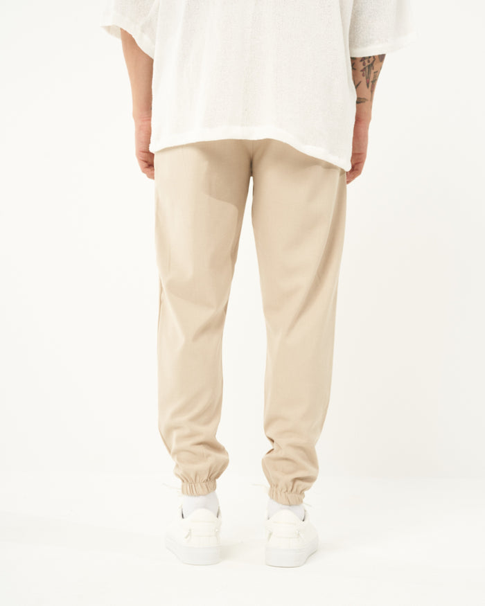Martin Valen men's beige jogger full-length view showing elastic cuffs at ankles and white sneakers