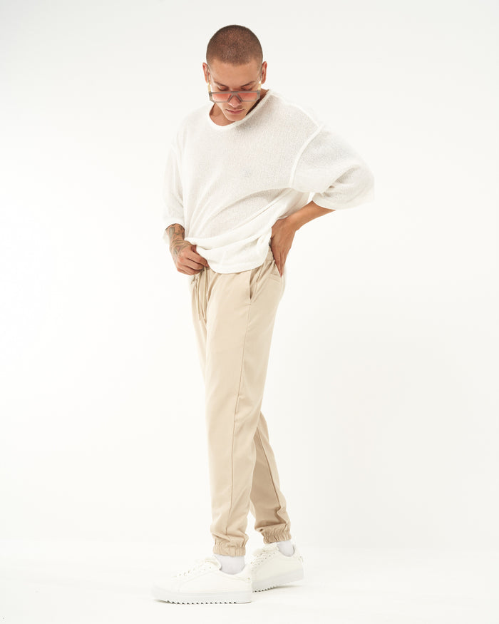 Martin Valen beige elastic-cuffed men's jogger, full view with model looking down and relaxed posture
