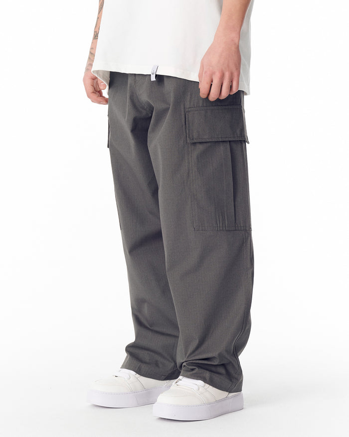 Martin Valen men's relaxed anthracite cargo pants, three-quarter view showing right side pocket and white sneakers