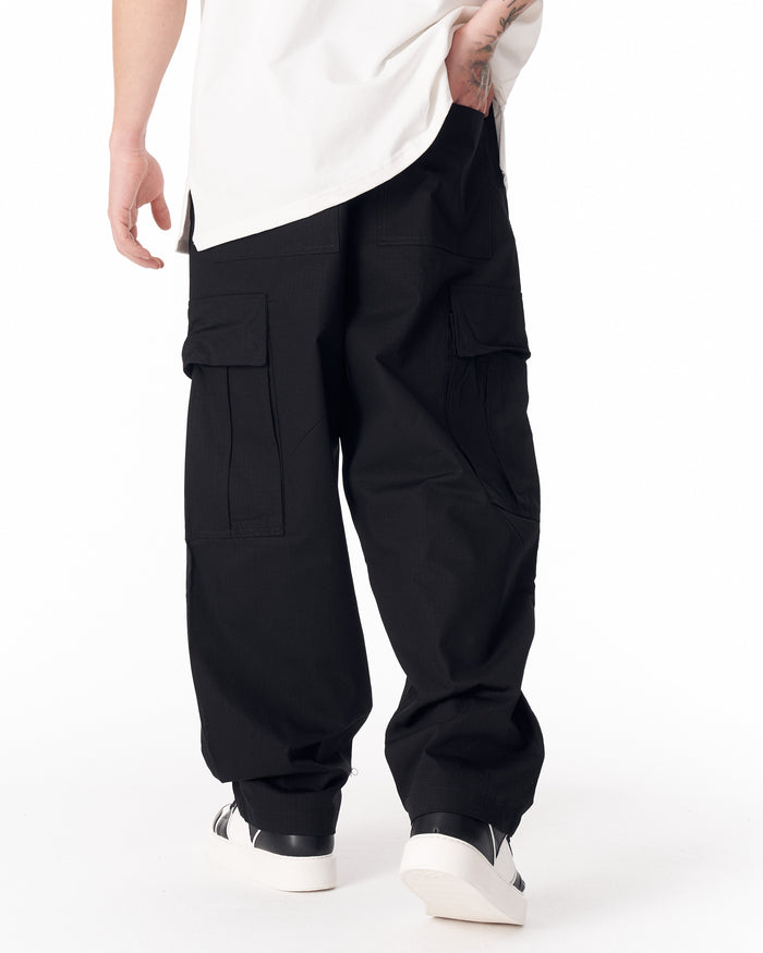 Martin Valen men's black relaxed cargo pants, rear close-up showing large flap pockets and loose hem