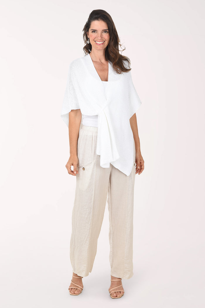 Woman wearing a white top and beige pants on a white background