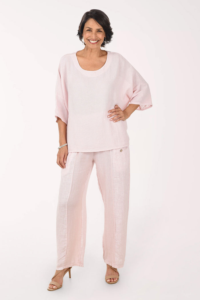 Woman wearing a light pink outfit on a white background