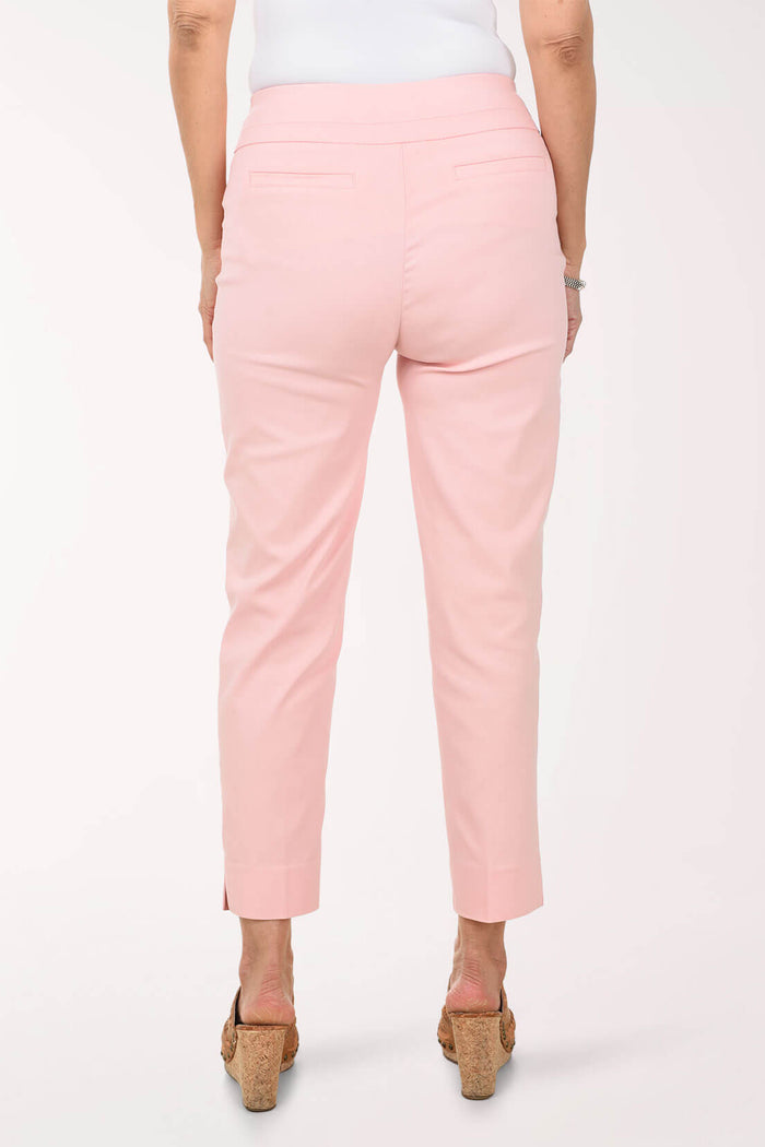 Person wearing light pink pants on a white background - back shot