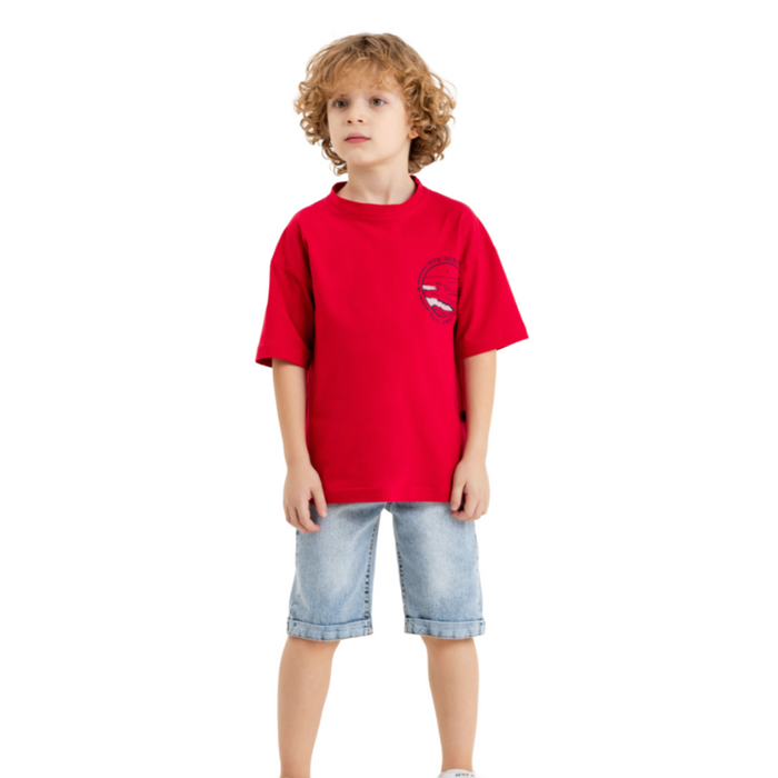 Young boy wearing a bright red T-shirt with a small chest graphic and light blue knee-length denim shorts.