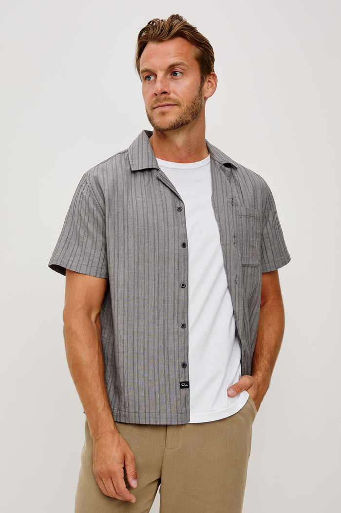 Ohana Button-Up Shirt in Textured Shirting WIth Short Sleeves, Collar, and Relaxed Fit in Charcoal Chambray Colorway - Upper Body Front View Featured on Model