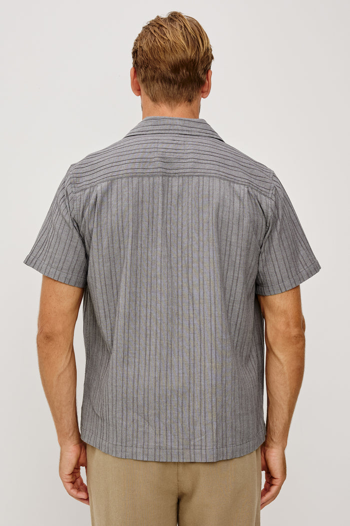 Ohana Button-Up Shirt in Textured Shirting WIth Short Sleeves, Collar, and Relaxed Fit in Charcoal Chambray Colorway - Upper Body Back View Featured on Model