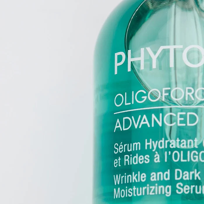 Close-up of a green bottle of Oligoforce Advanced Wrinkle & Dark Spot Correction Moisturizing Serum with Oligomer | Phytomer, highlighting skincare product details.
