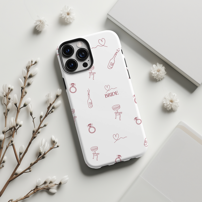 Blush pink tough phone case with bridal-themed doodles, flowers, and stationery accents.