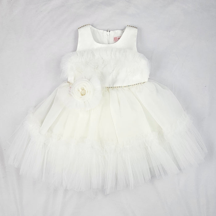 White baby girl tulle dress with layered skirt, floral waist detail and soft sleeveless bodice displayed on a white background.