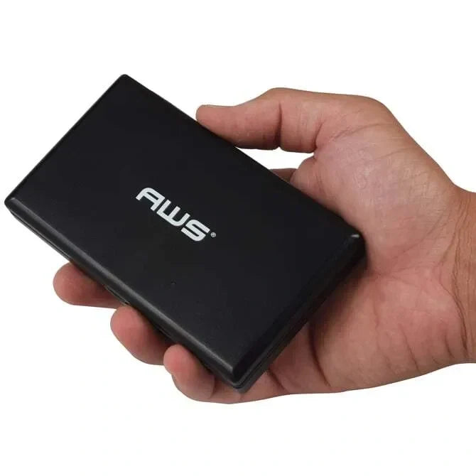 A digital pocket scale with a black protective cover and stainless steel weighing platform, featuring a digital LCD display being hand held with the cover displaying "AWS" on white background.