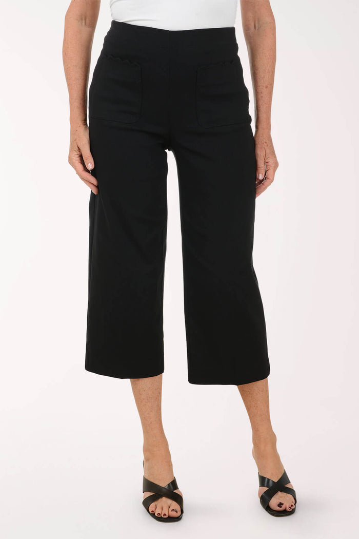 Person wearing black wide-leg pants on a white background