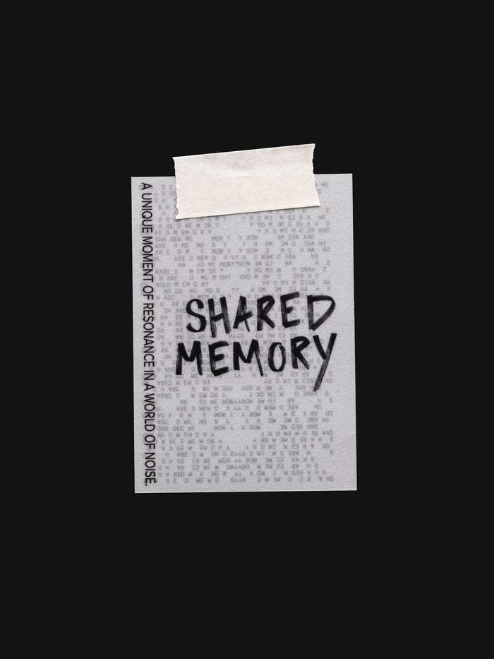 Translucent vellum journaling card with a black printed text design reading "Shared Memory" shown with tape on the top.