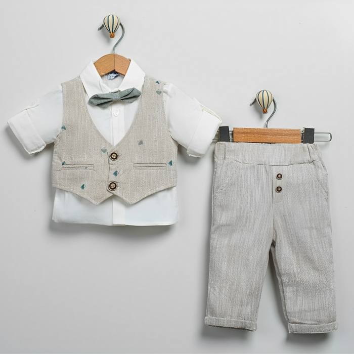 Baby boy outfit with white shirt, beige vest with bow tie, and matching beige pants on hangers.