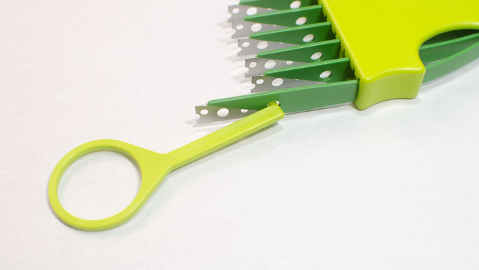 Light and dark green 6 blade bread lame or bread scorer and tool demonstrating how to remove or reorder the individual blades with the provided tool.