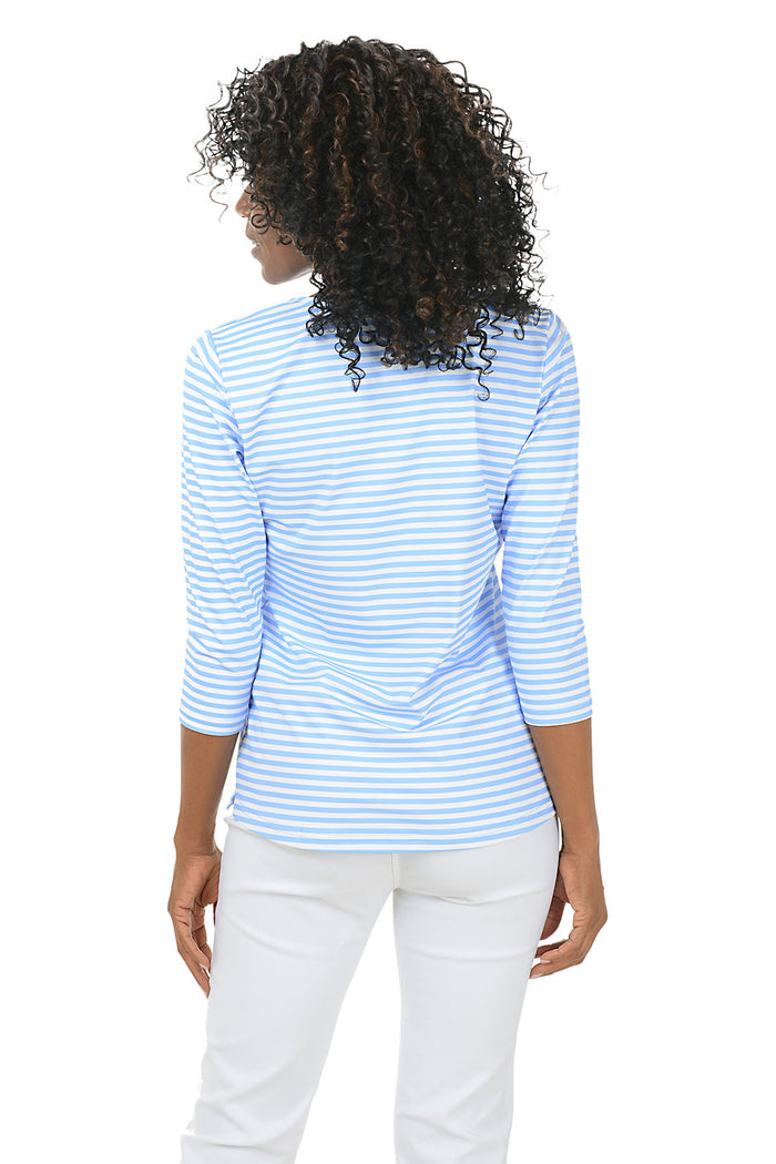 Woman wearing a blue and white striped shirt on a white background. Back shot.