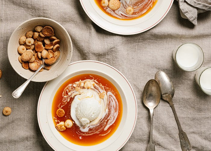 Traditional Swedish nyponsoppa rosehip soup served in bowls with vanilla ice cream and Cloetta Mandelbiskvier almond biscuits on a linen table