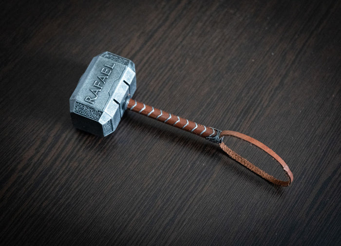 Thor Hammer Miniature 1:4 scale hand-painted Mjolnir replica with personalized engraving and leather strap on dark wood surface