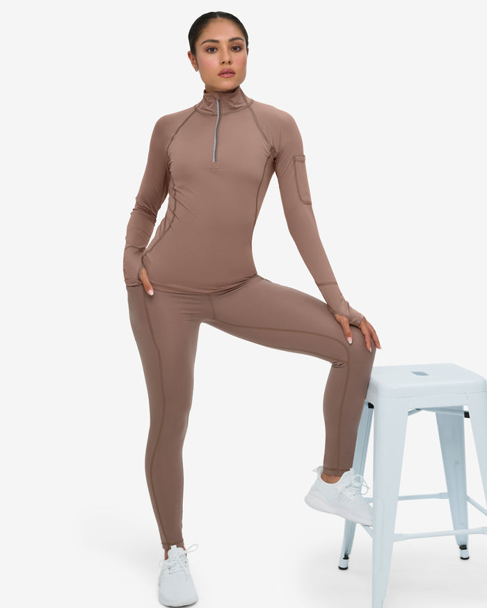 Woman wearing a brown athletic outfit on a white background