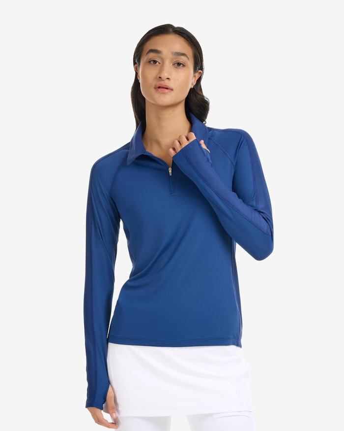 Woman wearing a blue long-sleeve top on a white background
