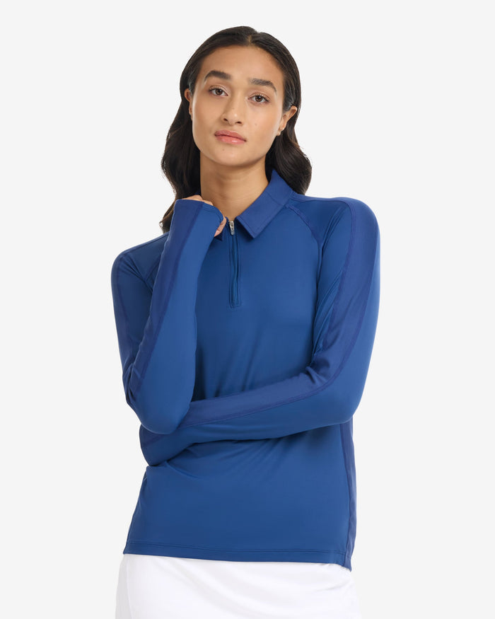Woman wearing a blue long-sleeve top on a white background